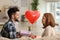 Young man giving present to his beloved girlfriend at home. Celebration of Saint Valentine\'s Day