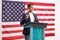 Young man giving a speech on a pedestal with the USA flag behind