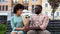 Young man giving white flower bouquet to woman sitting bench, first awkward date