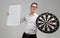 Young man in glasses with target with Darts in center and an empty Board in his hands isolated on white background