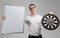 Young man in glasses with target with Darts in center and an empty Board in his hands isolated on white background