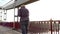 Young Man Goes Dancing Along The Bridge With Retro Rails in Summer in Slo-Mo