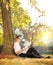 Young man on a grass reading newspaper in a park on a sunny day