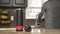 Young man in a gray T-shirt pours water into a glass from a stainless steel thermos or plastic bottle in a beautiful