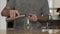 Young man in a gray T-shirt pours water into a glass from a stainless steel thermos or plastic bottle in a beautiful