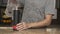 Young man in a gray T-shirt pours water into a glass from a stainless steel thermos or plastic bottle in a beautiful