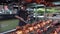 A young man grills barbecue on a grill in a busy market.