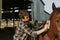 Young man grooming his horse