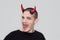 Young man with halloween horns and sticking his tongue out