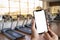 Young man Hand holding smartphone in gym to fitness phone fitne