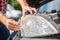 Young man hands changing car bulb or flashbulb of the front headlight or headlamp, repairing car concept