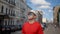 A young man in a hat walks around the city examines the buildings around, camera movement