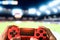 Young man having fun playing online soccer video games - Close up red magma game pad on tv background