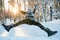 Young man having fun in snow outdoors in winter, jumping.