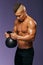 Young man having kettlebell exercises at gym