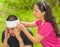 Young man with head injury receiving treatment and bandage around skull from woman, outdoors environment