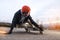 Young man in helmet is going to slide, slide with sparks on a longboard on the asphalt