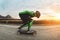 A young man in helmet and a leather suit in a special rack rides a longboard on afsaltu on background mountains and