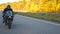 Young man in helmet riding fast on modern sport motorbike at autumnal highway. Motorcyclist racing his motorcycle on