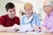 Young Man Helping Senior Couple With Financial Paperwork At Home