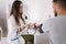 Young man with high blood pressure. Female doctor using sphygmomanometer with stethoscope checking blood pressure to a