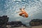 Young man high jumping on beach