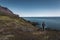 Young man hiker in the arctic landscape of Disko Bay in Greeland in Summer. Blue Sky and green meadows. Arctic Circle