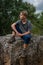 Young man hiker resting  on large rock in the french countryside ,adventure walking holiday