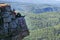 Young man hiker sitting on top of a mountain, relax and enjoy by scenic view. Full length shoot with copy space. Summer