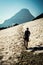 A young man hikes a snowy trail in Glacier National Park Montana under a clear blue sky