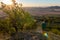 Young man hiking to hill with trees. Czech ore mountain landscape at sunrise