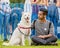 A young man with his beautiful dog in the park at a dog show