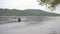 Young man and his son paddle in an inflatable kayak in a bay or a lake. Slowmotion shot