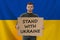 Young man holding banner with inscription stand with Ukraine, collage
