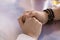 Young man holding female hands on tabletop, expressing love