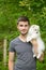 Young man holding german spitz puppy