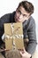 Young man holding a gold wrapped gift