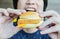 Young man holding in male hands fast food burger, american unhealthy calories meal on background,