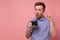 Young man holding photocamera taking photo pointing with index finger up giving advice