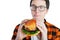 Young man holding a piece of hamburger. Student eats fast food. Burger is not helpful food. Very hungry guy looks at the burger