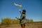 Young Man Holding A Radio Or Remote Control launches an airplane in a field.