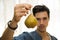 Young man holding a ripe yellow pear