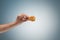 A young man is holding a roasted chicken drumstick