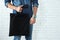 Young man holding textile bag against brick wall, closeup