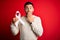 Young man holding white ribbon as stop women violence and lung cancer awareness cover mouth with hand shocked with shame for