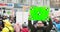 Young man holds poster with green screen on crowd background in city demonstration.