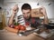 Young man at home kitchen in cook apron desperate in cooking stress