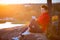 Young man in hoodie sitting on top of the rock