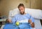 Young man in hospital room after suffering accident eating healthy apple diet clinic food moody and sad