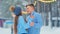 Young man hugs girlfriend in blue sweater on ice rink